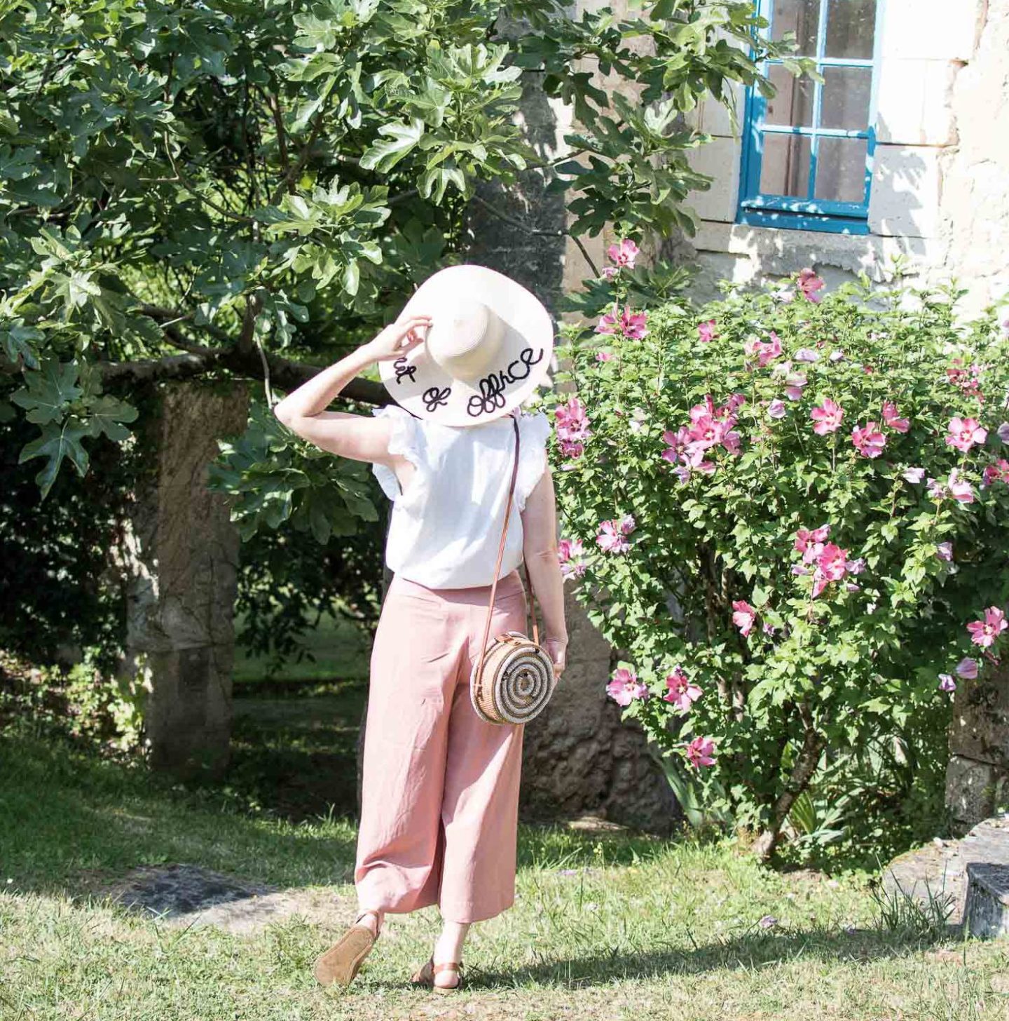 Fashion and Lifestyle Blogger Karen Maurice wearing an out of office hat, white ruffle slv top from Beaumont Organic and Pink Culottes from Oliver Bonas