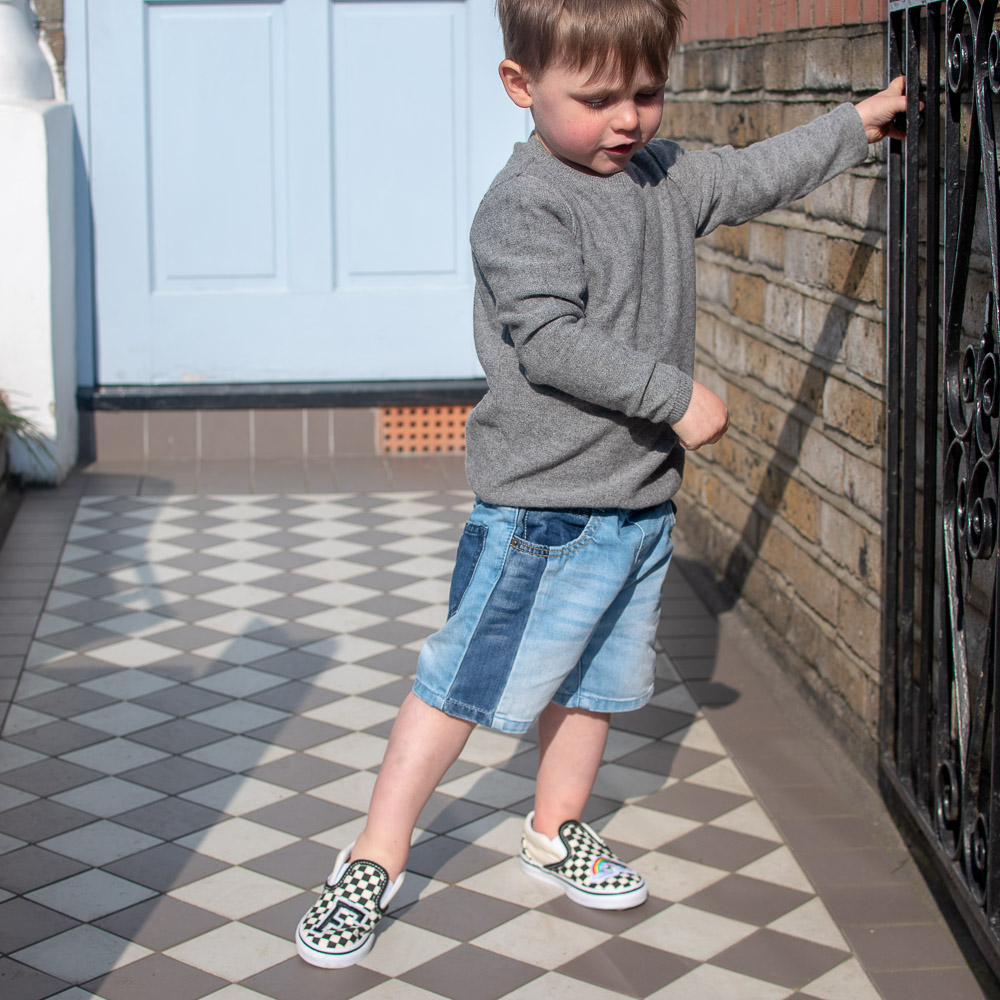 Laurie wears second-hand clothing from Slof, grey cashmere jumper, denim shorts and a pair of preloved Vans