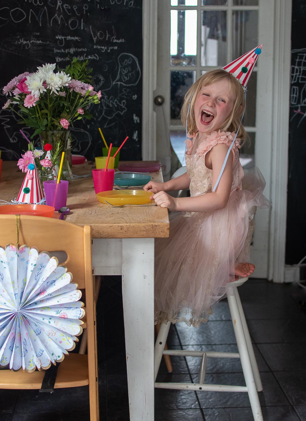 a paper pinwheel decoration and Daisy at her party table