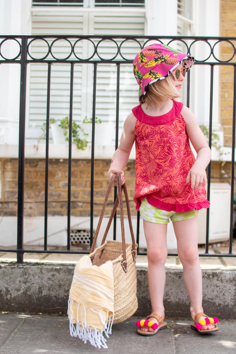 Daisy wears, pink sleeveless top from Loopster (preloved children's clothing), green shorts and a patterned sun hat from Little Hotdog Watson