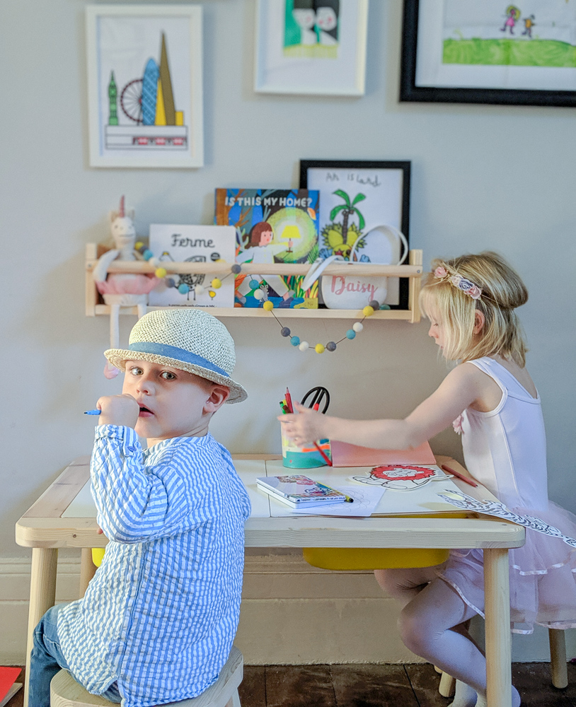 Kids of Karen Maurice of n4mummy drawing at a desk. Artwork on wall from Etsy.