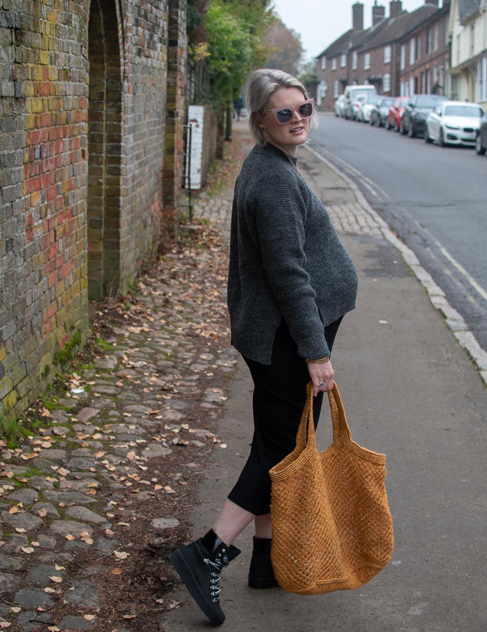 Karen Maurice of n4mummy wears a black midi length dress and waffle knit grey jumper from Boob at 36 weeks pregnant. With lace up boots from Shoe the bear