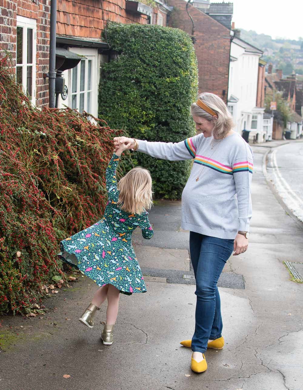 Karen Maurice of n4mummy wearing  a rainbow stripped maternity jumper from Frugi and skinny maternity jeans from Jo Jo Mamam Bebe with her daughter in a skater dress all from Frugi. Ethical Maternity Clothes