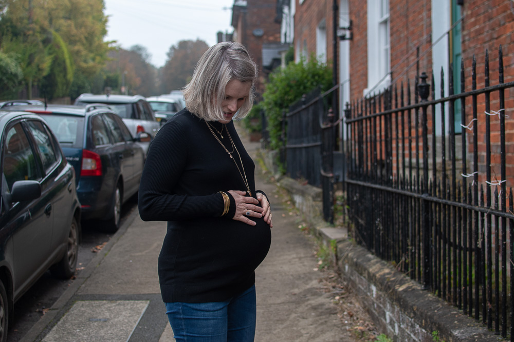 A side view of Karen from n4mummy wearing  a black turtle neck maternity jumper from Jo Jo Maman Bebe, Ethical Maternity Clothes
