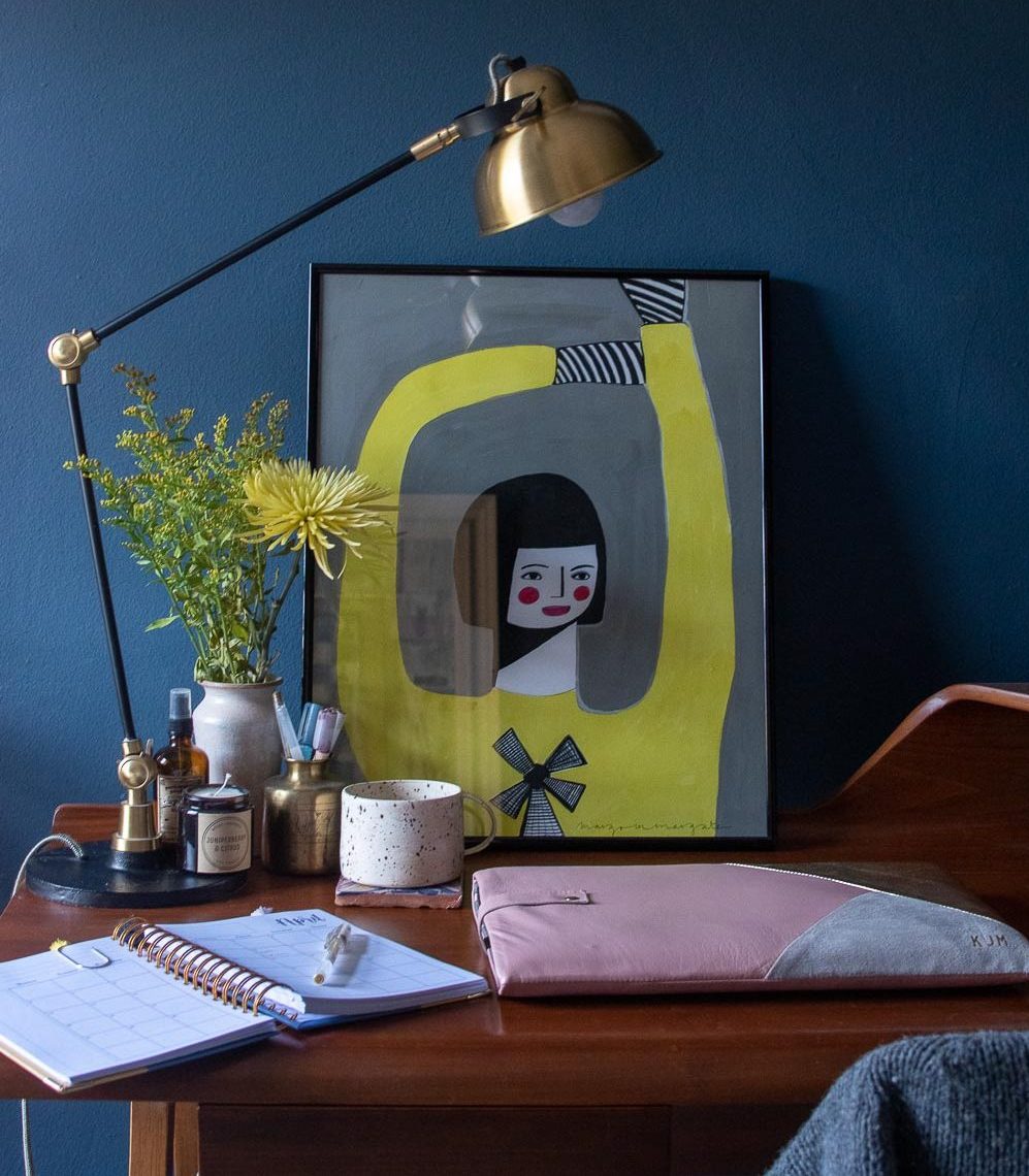 My home office with pieces from Etsy sellers. A picture of a girl in a yellow dress from Margo in Margate, a soy candle from Mooke, a speckled mug from Barton Croft, a leather laptop sleeve from Suede and Co and a diary from The West Twelve Paper Co. 