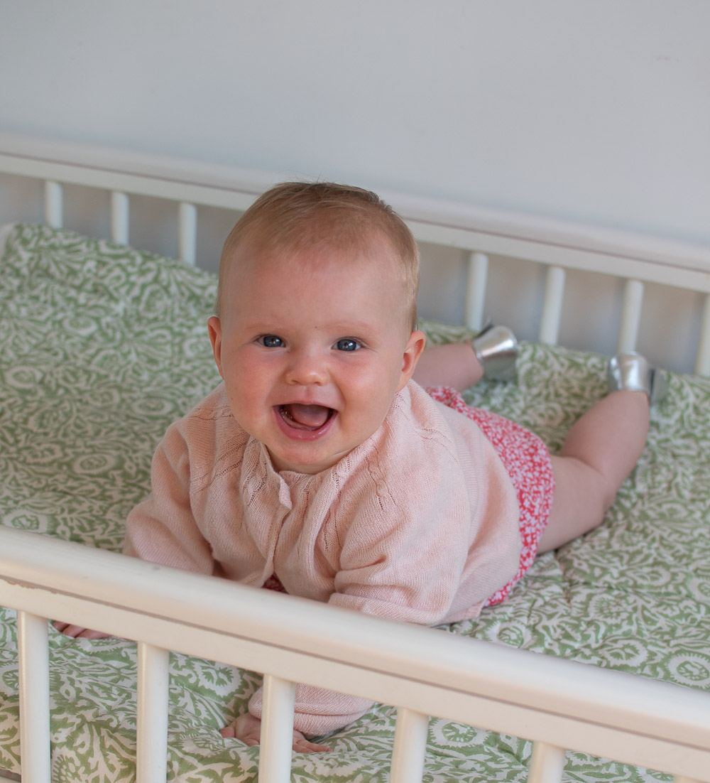 A baby wearing a pink cashmere cardi from Slof second-hand children's clothing brand