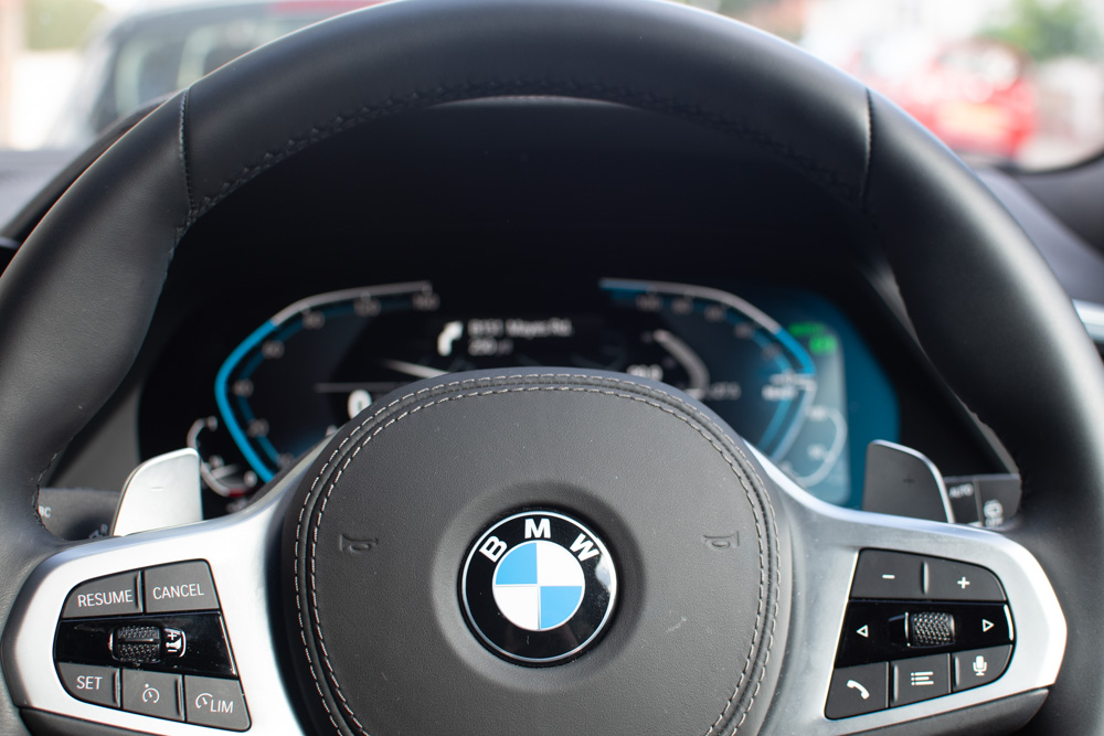 The steering wheel & dashboard of the BMW.