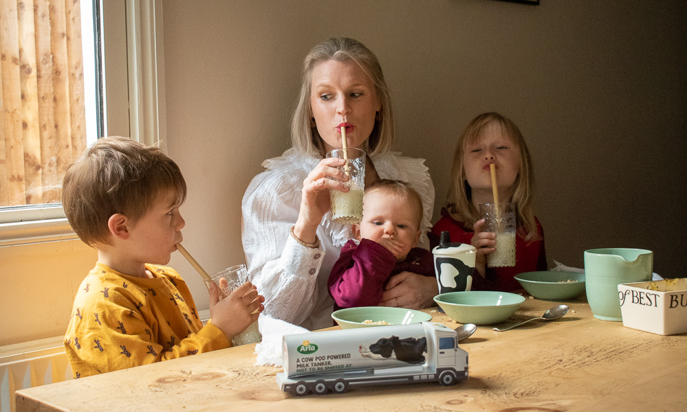 Karen Maurice sustainable blogger of n4mummy with her family at the breakfast table drinking milk. 