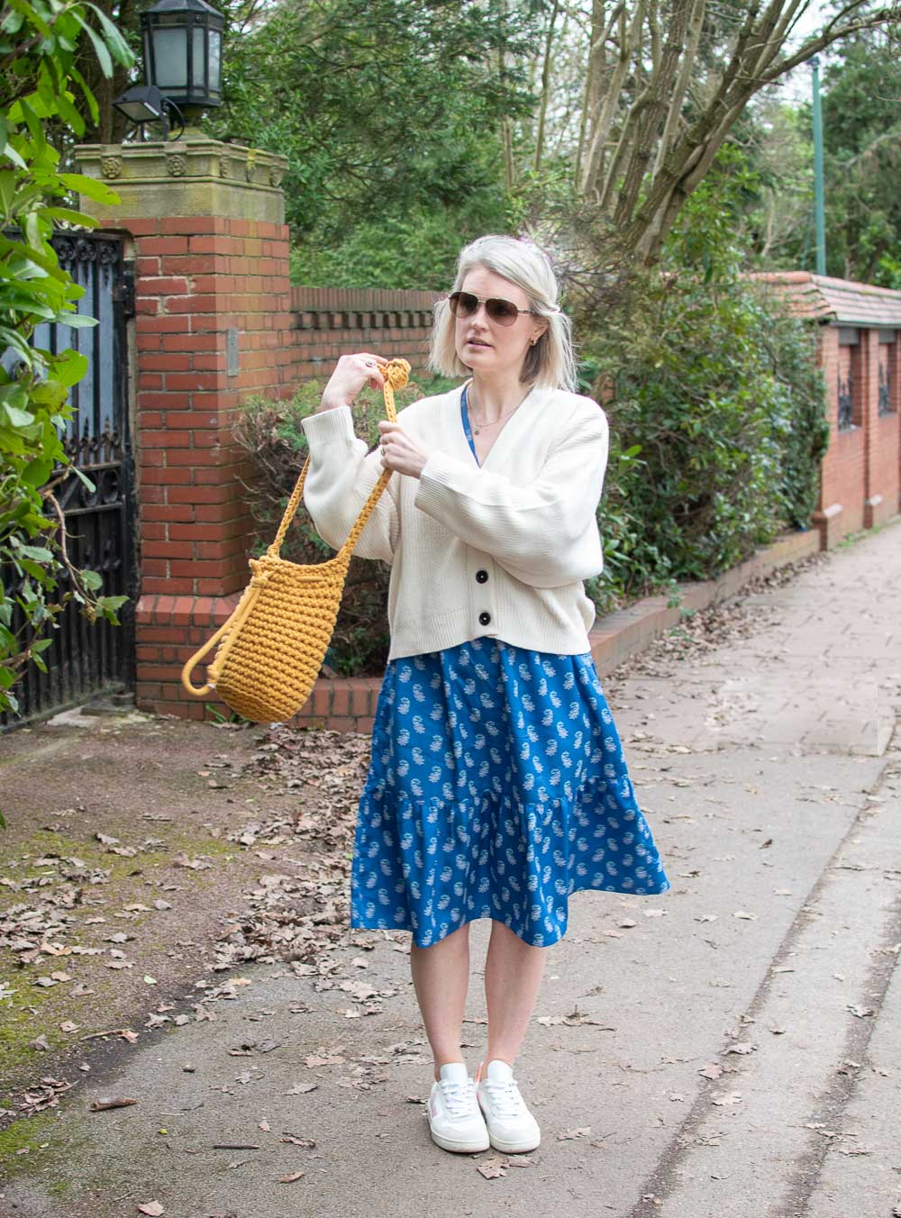 Karen Maurice, sustainable influencer of n4mummy, wears a blue patterned midi dress and a cream cardi from Fairtrade fashion brand People Tree